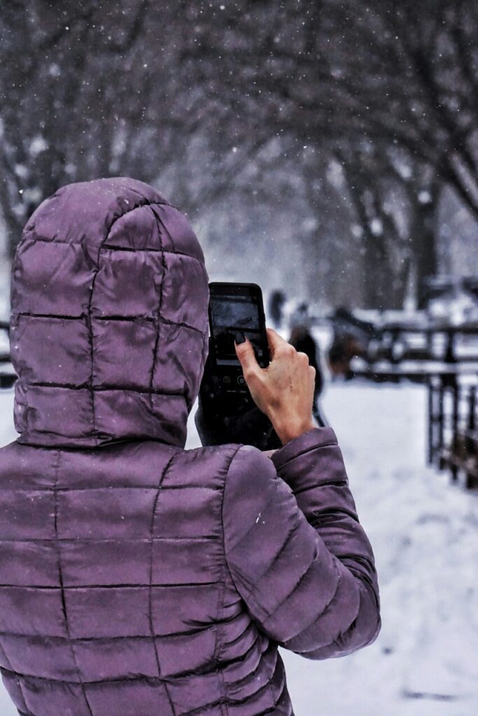 Frau mit Handy im Winter. Hält der Akku das aus?