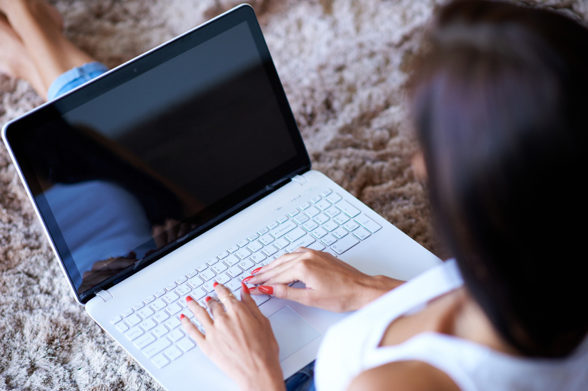 Frau sitzt vor schwarzem Bildschirm ihres Laptops