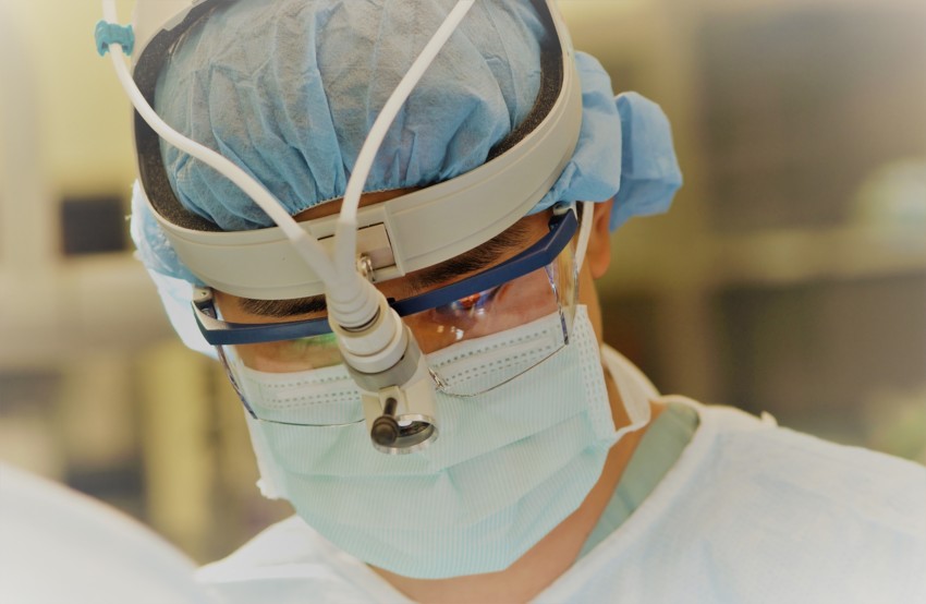 Chirurg bei einer Operation mit Stirnlampe Medizintechnik